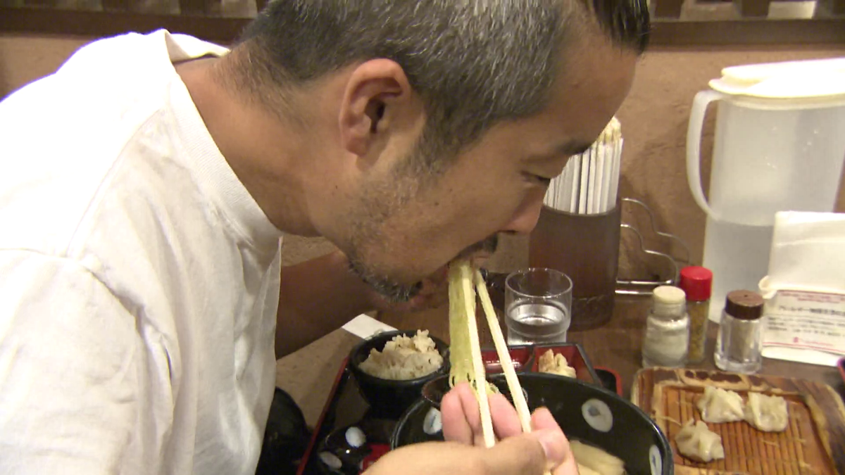 おいしそうに最後のラーメンを頬張る男性