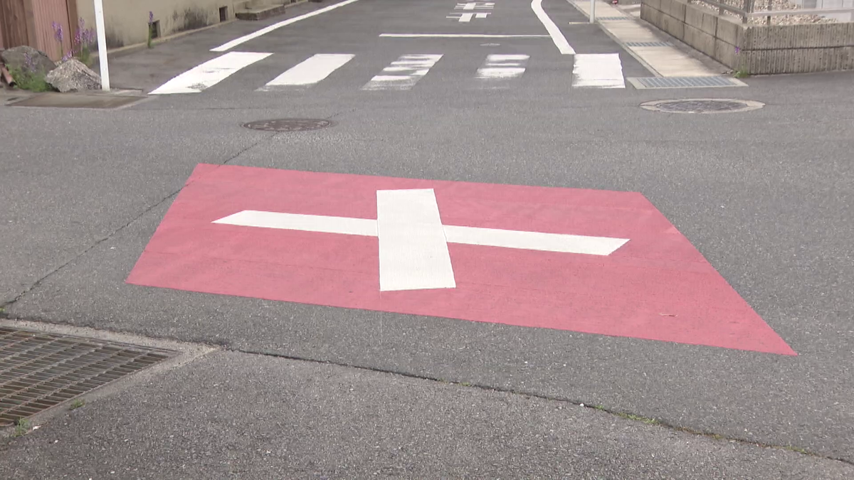 交通量の多い交差点に書かれた赤色に十字のマーク