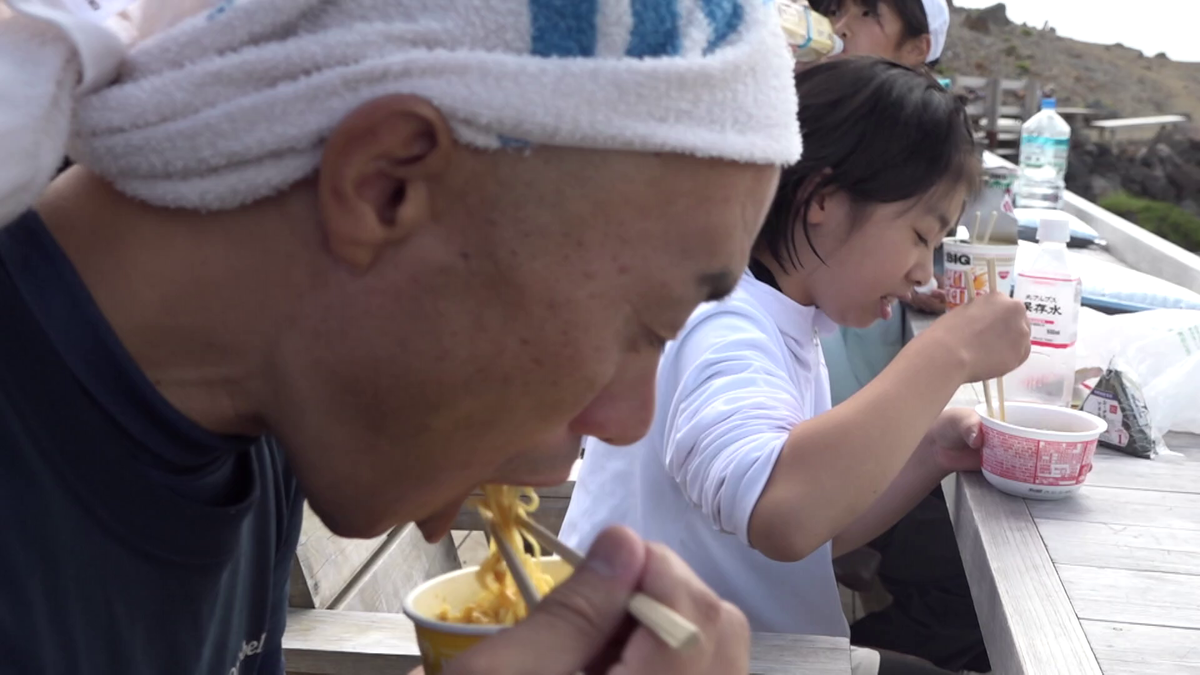 頂上でカップ麺を食べる今井さん親子