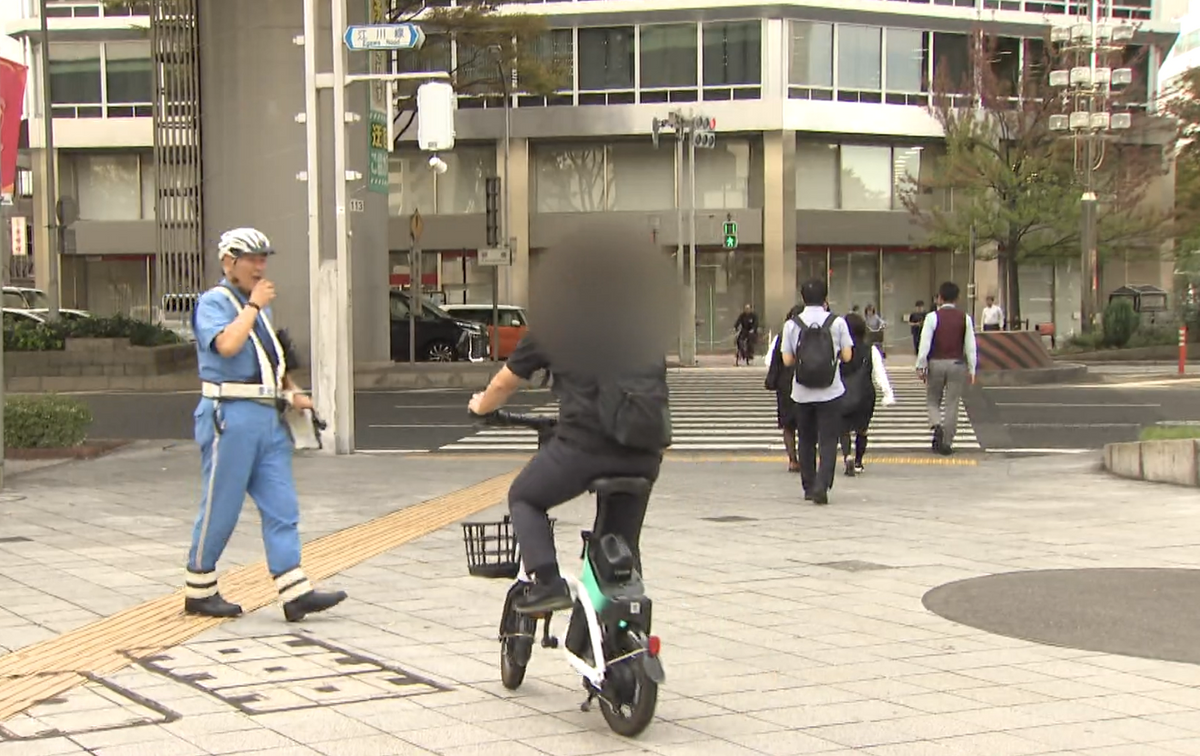 スマホを見ながらの自転車利用者を呼び止める警官