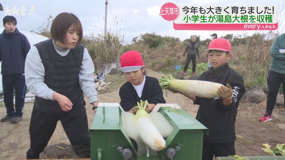 洗浄機で泥を落とす児童