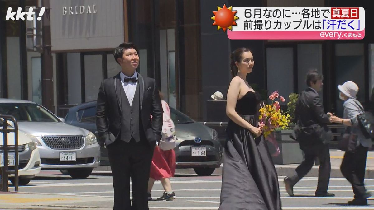 熊本城をバックに結婚式の前撮りを行うカップル