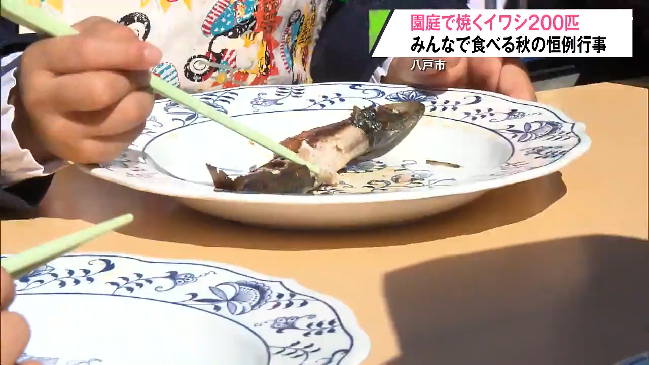 おいしくなぁれ！わー」秋恒例 園庭でイワシ焼き イワシを口いっぱいに