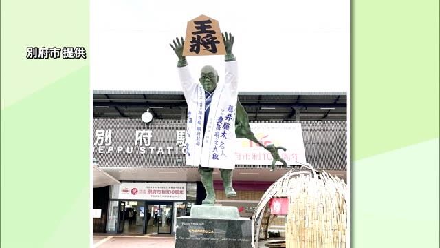 今月開催「藤井聡太八冠の名人戦」PR看板設置　油屋熊八の像も王将の駒を掲げ　盛り上げる　大分