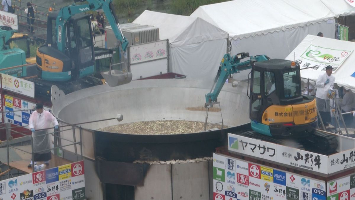 大鍋のふたを傘に　激しい雨の中「芋煮愛」あふれる　山形市の「日本一の芋煮会フェスティバル」